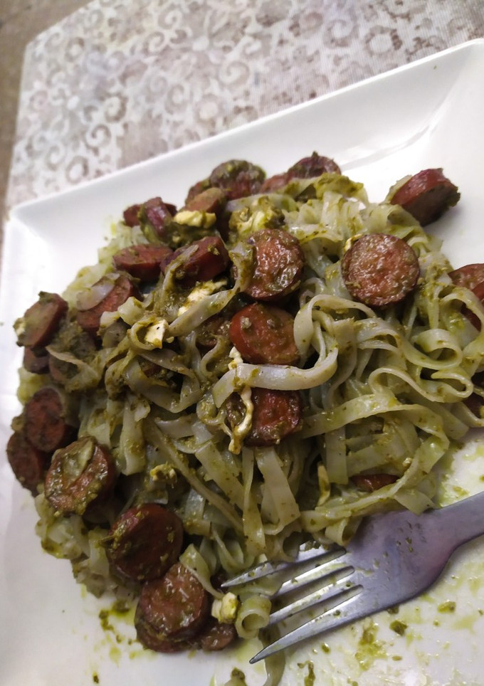 Una foto de Tallarines con salsa de pesto, salchichas y queso de cabra