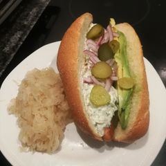 A picture of Sausage with tzaziki and sauerkraut.
