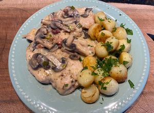Una foto de Escalopes de pollo con crema de champiñones y verdeo con papas noisettes