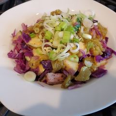 A picture of Italian sausages and vegetable skillet with spicy green harissa.