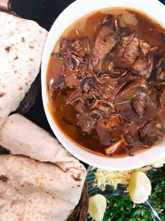 A picture of Beef Nihari with Naan.