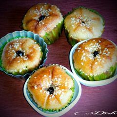 A picture of White sesame cup cakes with dried black currants.