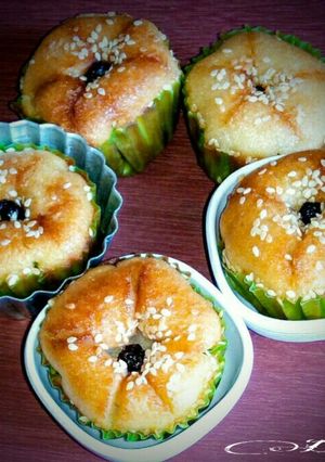 A picture of White sesame cup cakes with dried black currants.