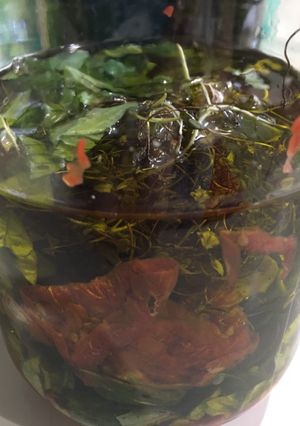 Una foto de Tomates deshidratados en conserva de ajo asado albahacas frescas y orégano