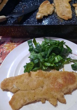Una foto de Milanesas de pescado (sin complicaciones) y hojas de espinaca