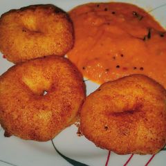 A picture of Medu vada with tomato onion chutney.