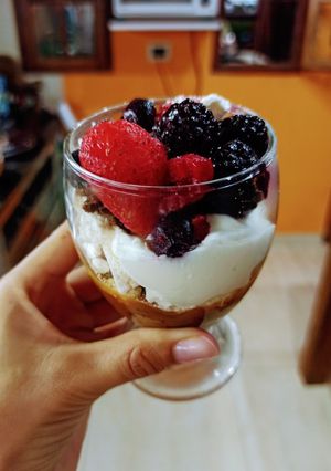 Una foto de Copita de brownie, dulce de leche, merengues, crema y frutos rojos