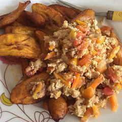 A picture of Fried plantain with fried egg and tomatoes.