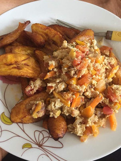 A picture of Fried plantain with fried egg and tomatoes.
