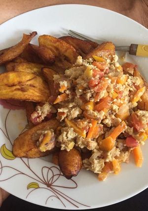 A picture of Fried plantain with fried egg and tomatoes.