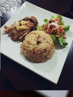 Una foto de Pavo en salmuera arroz en salsa de tocino y ensalada griega