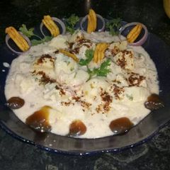 A picture of Dahi aloo chat with onion.