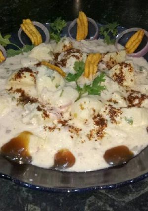 A picture of Dahi aloo chat with onion.