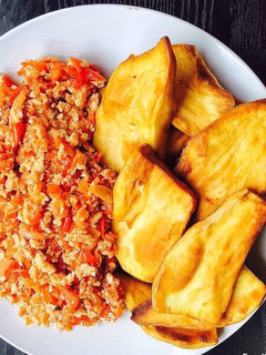 A picture of Scrambled eggs and sweet Potato fries.