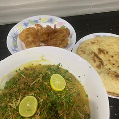 A picture of Haleem with roti and jalebi.