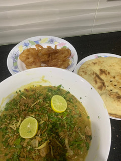 A picture of Haleem with roti and jalebi.