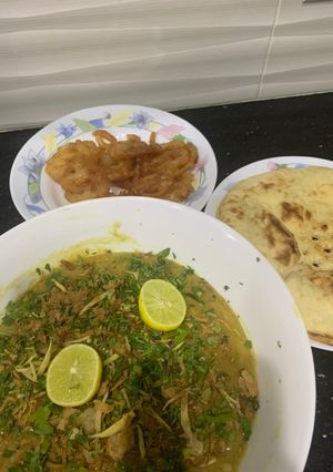 A picture of Haleem with roti and jalebi.