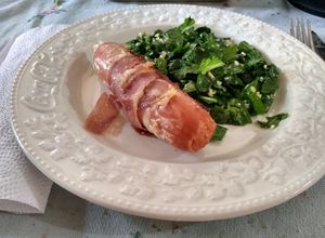 Una foto de Chorizo alemán envuelto en jamón crudo con ensalada de rúcula y queso pategras