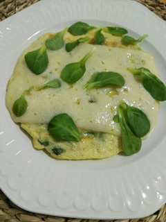 Una foto de Tortilla de atún, queso y canónigos con cubierta de queso