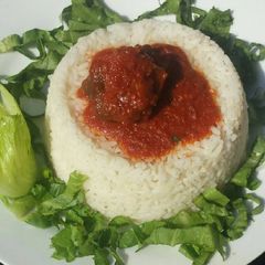 A picture of Rice and stew served with lettuce.