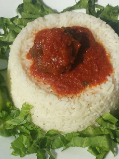 A picture of Rice and stew served with lettuce.
