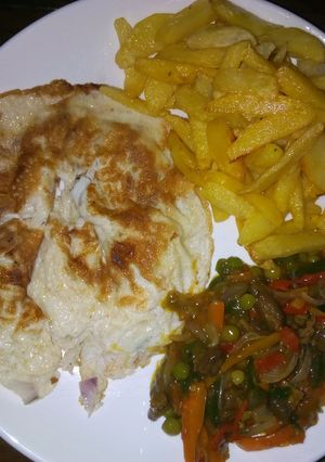 A picture of Chips,fried egg and veggies sauce.