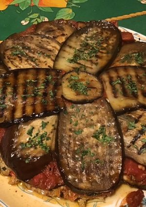 Une photo de Aubergines grillées façon gâteau aux tomates, farce au chapon, pesto et emmental