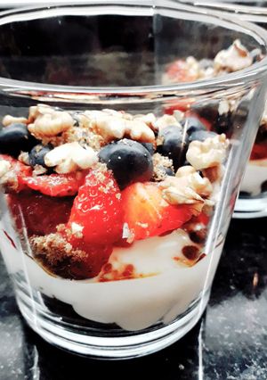 Una foto de Postre en vaso frutillas, nueces y arándanos