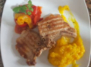 Una foto de Costillitas de cerdo, con puré de mango y morrón asado