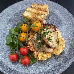 A picture of Curry Dusted Cauliflower ‘Steak’ Topped With Chive and Garlic Mushrooms.