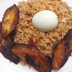 A picture of Jollof rice, fried plantain and egg.