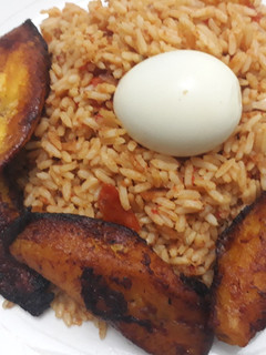 A picture of Jollof rice, fried plantain and egg.