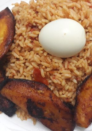A picture of Jollof rice, fried plantain and egg.