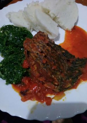 A picture of Wet fry fish with sukuma and ugali.