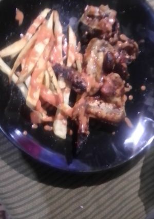A picture of Chickens wings and fried chips.