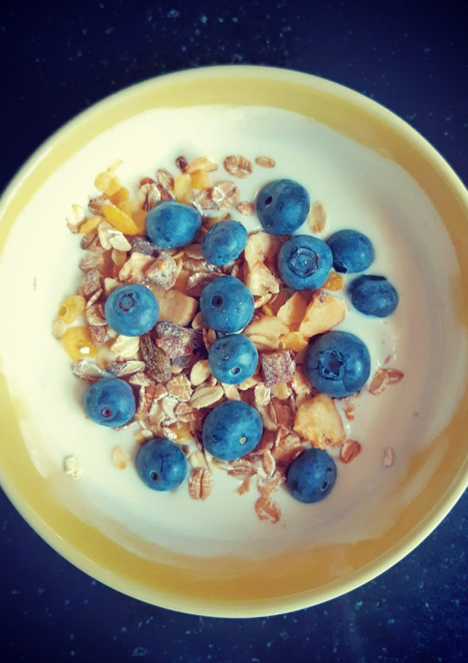 Una foto de Desayuno de yogurt natural con coco, con arándanos y muesli