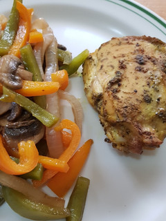 Una foto de Muslos a la mostaza con guarnición de pimientos y champiñones