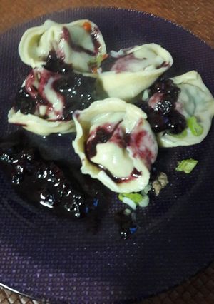 Una foto de Agnolottis primavera con salsa de arándanos