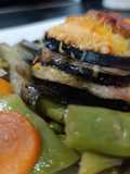 Milhojas de berenjena con solomillo queso y cama de verduras