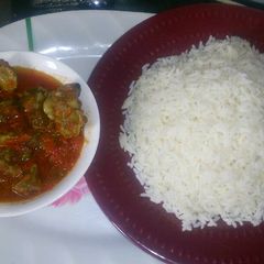 A picture of White rice and goatmeat stew.