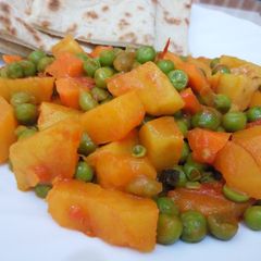 A picture of Sweet Potato Curry and peas served with naan bread.