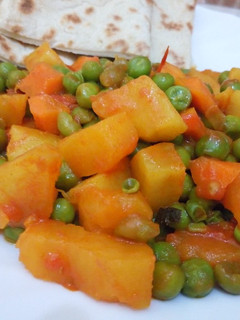 A picture of Sweet Potato Curry and peas served with naan bread.