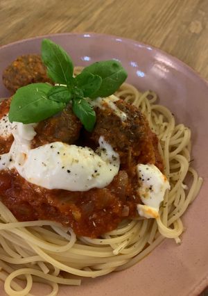 A picture of Meatballs in a rich tomato sauce with mozzarella.