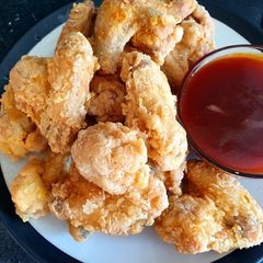 A picture of Light and crispy chicken wings.. sweet/sour sauce.