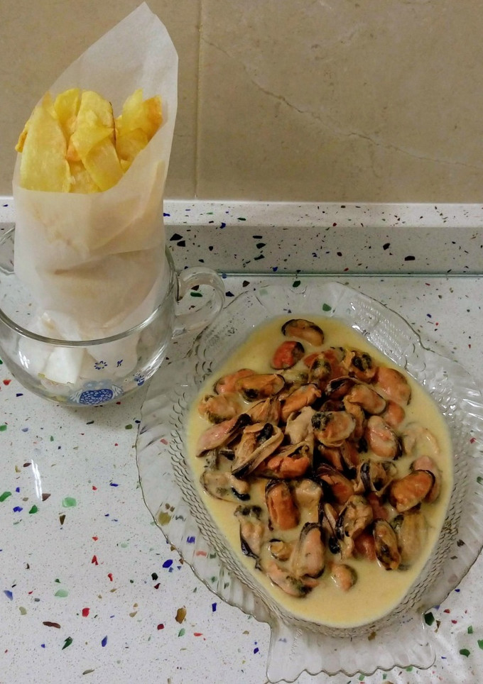Una foto de Papelón de patatas fritas con mejillones en crema de nata y chalotas