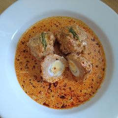A picture of Quail eggs-stuffed chicken meatballs with creamy sauce.