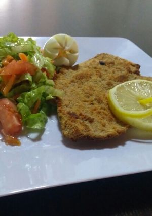 Una foto de Milanesa con ensalada de lechuga y tomate