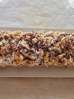 Una foto de Pastel muy bonito, divertido y suave con chocolate, nata y almendras