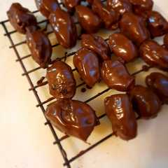 A picture of Dátiles rellenos con nuez bañados en chocolate semiamargo.