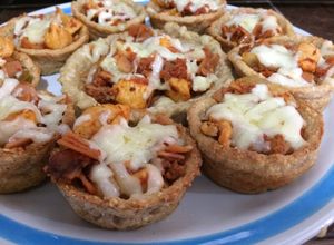 Una foto de Canastitas de papa rellenas de un guiso o vegetales con queso